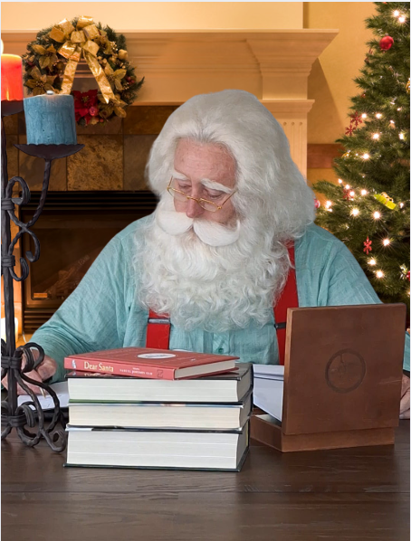 Santa Troy writing at a Christmas desk